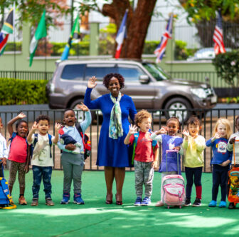 imani-montessori-school-director-with-happy-children-waving